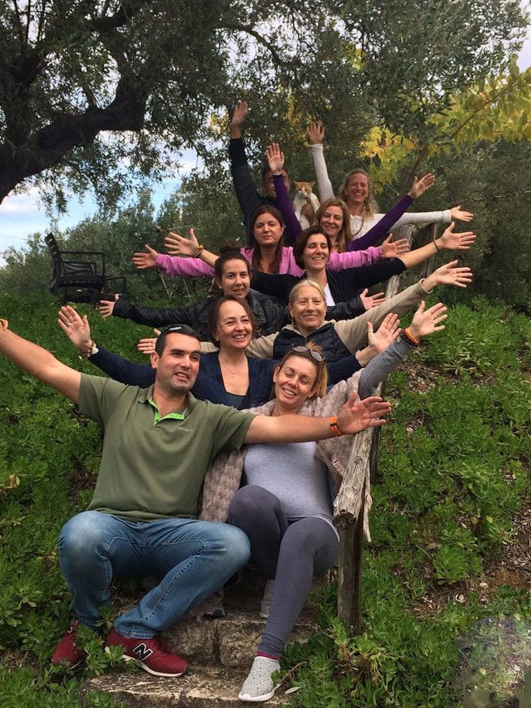 tourists on the hill one behind the other with open arms and smiling and watching at the camera at 'Eleonas' in nature